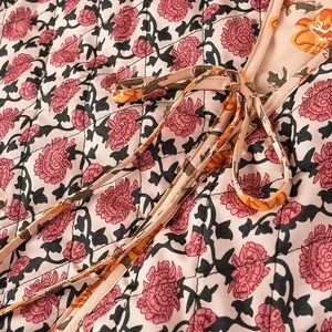 Close-up detail of vintage floral print and tie-up design on quilted women's vest waistcoat.
