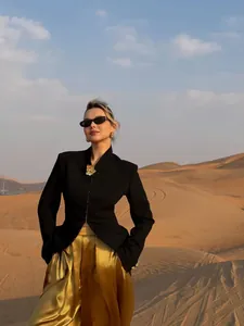 Elegant black mermaid blazer paired with a luxurious gold satin skirt in a desert setting.
