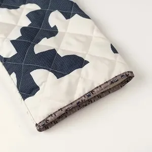 Close-up detail of quilted sleeve with intricate pattern and striped floral cuff piping