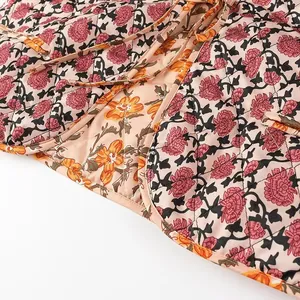 Close-up of floral quilted vest with delicate tie straps and stitching details