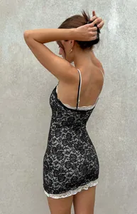Dettaglio di un abito sottoveste in pizzo bianco e nero con finiture floreali eleganti.