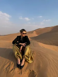 Elegant black single-breasted blazer and gold satin wide-leg pants in desert setting