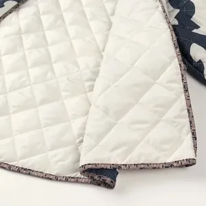Detailed macro view of white quilted lining with elegant floral trim on kimono jacket