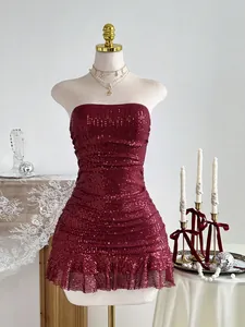 Détail d'une robe bustier élégante à paillettes bordeaux sur un mannequin de couture