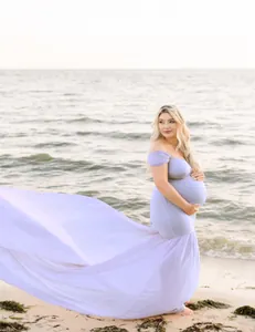 Lavender maternity photography dress with a long flowing chiffon train on a beach