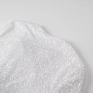 Macro view of white sequined fabric detail on elegant women's jacket for spring