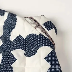 Close-up view of the side pocket detail on a women's blue and white quilted kimono coat