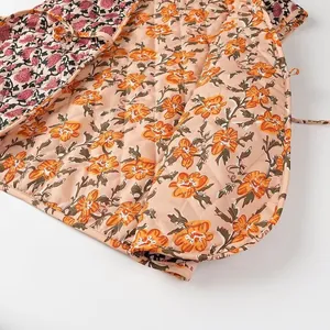 Close-up of vintage floral print and diamond quilting on women's fashion vest.
