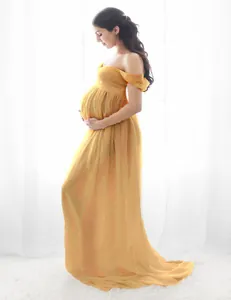 A detailed side view of an elegant yellow floor-length maternity dress for photoshoots.