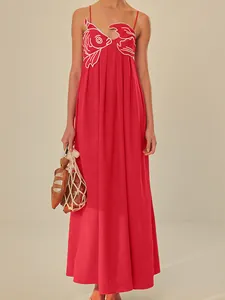 Detailed view of red maxi slip dress with unique goldfish embroidery on the bodice