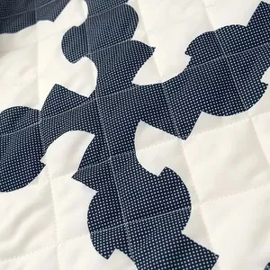 Close-up detail of quilted navy polka dot print fabric on a stylish winter kimono coat