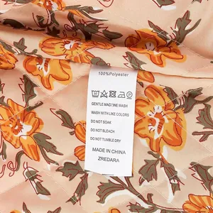 Close-up of care label on a floral print polyester vest showing wash instructions.
