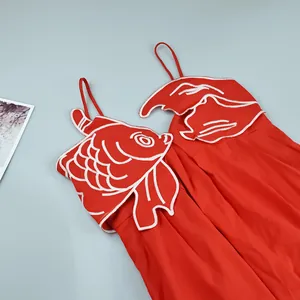 Close-up detail of the intricate white goldfish embroidery on a red sweet style slip dress