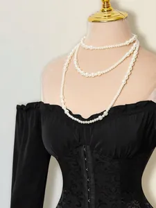 Primo piano di un abito a corsetto nero con spalle scoperte e dettagliati fiori jacquard