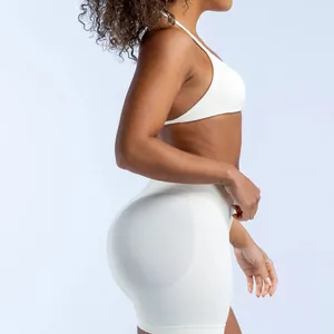 Side view of seamless white halter yoga bra and high-waisted shorts set on model