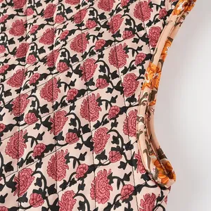 Close-up of a floral quilted vest featuring detailed armhole stitching and orange lining.