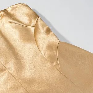 Macro detail of luxurious metallic gold fabric and precise stitching on blazer jacket