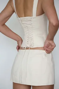 Detailed back view of a cream cotton lace-up corset top with adjustable lacing strings