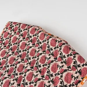 Macro view of detailed quilted pink floral print fabric on a stylish women's vest