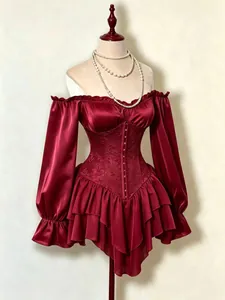 Dettaglio di un abito a corsetto bordeaux con spalle scoperte, jacquard e balze