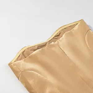 Close-up detail of champagne gold satin mermaid skirt showing fabric texture.