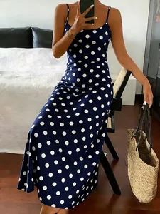 Close-up of elegant navy blue polka dot maxi dress featuring thin adjustable straps