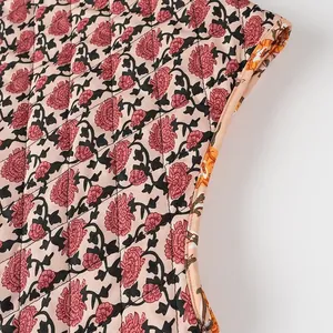 Macro view of vintage pink floral print detail on high-quality quilted sleeveless vest