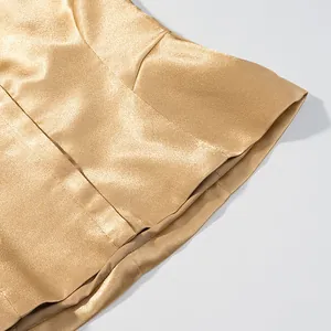 Macro detail of the shimmering metallic gold fabric and neat hem stitching of skirt