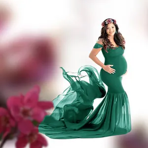 Elegant green maternity gown with long chiffon tail for professional photography.