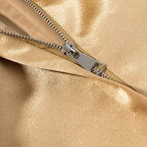 Detail shot of the smooth silver metal zipper on the premium gold metallic fabric