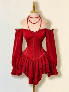 Dettaglio dell'abito a corsetto rosso con spalle scoperte, orlo a balze e maniche lunghe