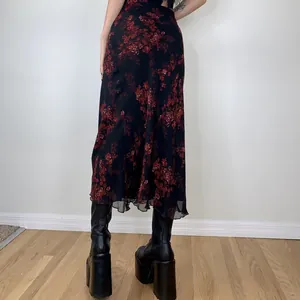 Back view of an elegant black midi skirt with a vintage red floral print and slim fit
