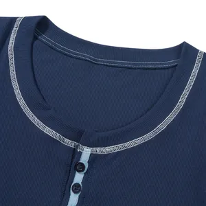 Dettaglio della maglia a coste blu navy con cuciture a contrasto e chiusura con bottoni.