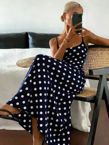 Detailed view of an elegant navy blue dress with large white polka dot print