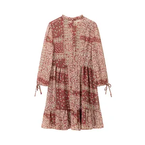 Détail d'une robe à imprimé floral patchwork avec poignets noués et jupe à volants