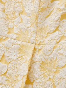 Close-up macro detail of yellow and white 3D floral jacquard fabric texture