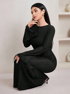 Robe élégante en maille jacquard noire avec manches cloches et une silhouette sirène.