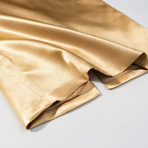 Close-up view showing the golden metallic satin fabric hem with slit detail for suit set