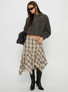 Ganzkörperansicht einer Frau mit einem asymmetrischen Midi-Karo-Rock mit hoher Taille.