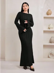 Vue détaillée d'une robe longue en maille jacquard noire avec des manches cloche.