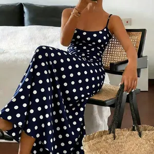 Elegant navy blue polka dot maxi dress with thin straps for a stylish and slim summer fit.