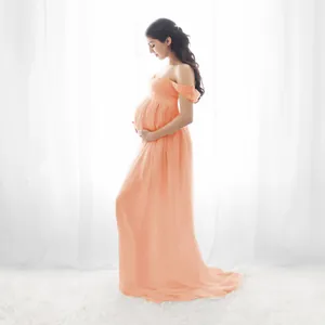 Full-length view of an orange off-the-shoulder maternity gown for photo shoots