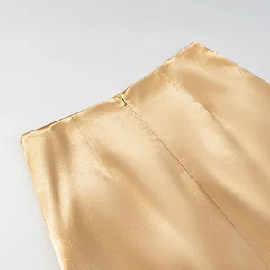 Close-up detail of champagne gold satin skirt showing waistline and hidden zipper
