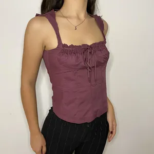 Vista dettagliata di un corsetto viola senza maniche con elegante bordo in pizzo