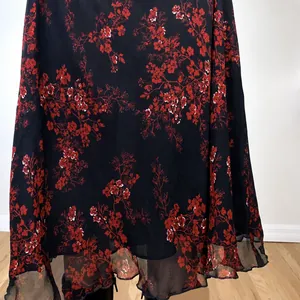 Ethnic style floral print midi skirt featuring elegant red flower patterns on black fabric