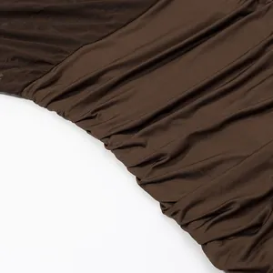 Makro-Detailansicht der Textur und Raffung eines braunen Kleides aus elastischem Netzstoff.