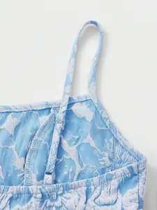 Detailed view of light blue 3D floral jacquard fabric and adjustable shoulder strap