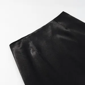 Detailed view of elegant black satin mermaid skirt waist showing smooth glossy texture