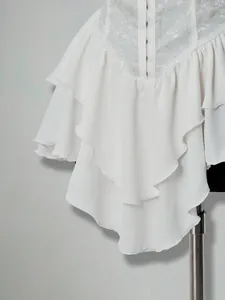 Close-up of white jacquard patchwork and tiered ruffle hem on chiffon mini dress