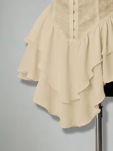 Close-up of cream layered ruffle hem on chiffon mini dress with elegant jacquard details.